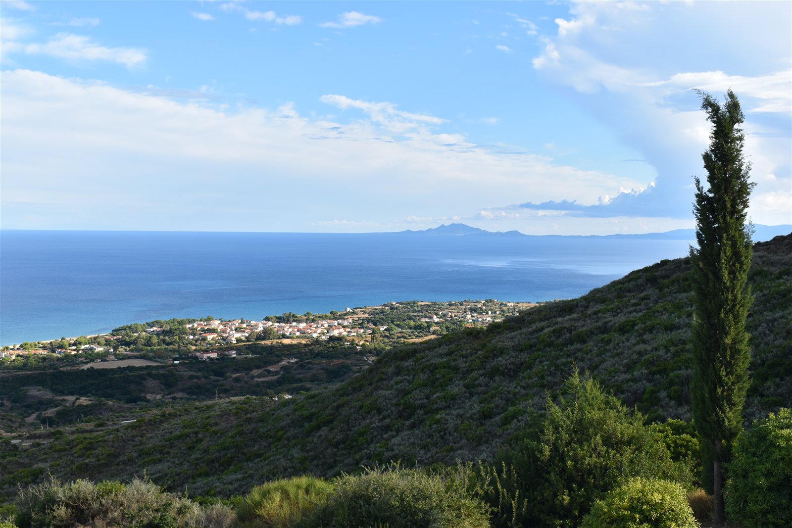 Green hills falling towards Skala and the deep blue Ionian Sea