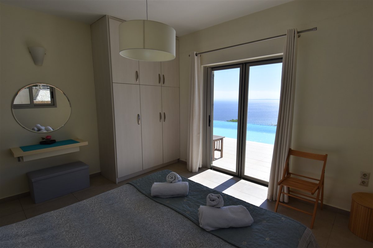 Ground-floor double bedroom with doors opening directly towards the pool