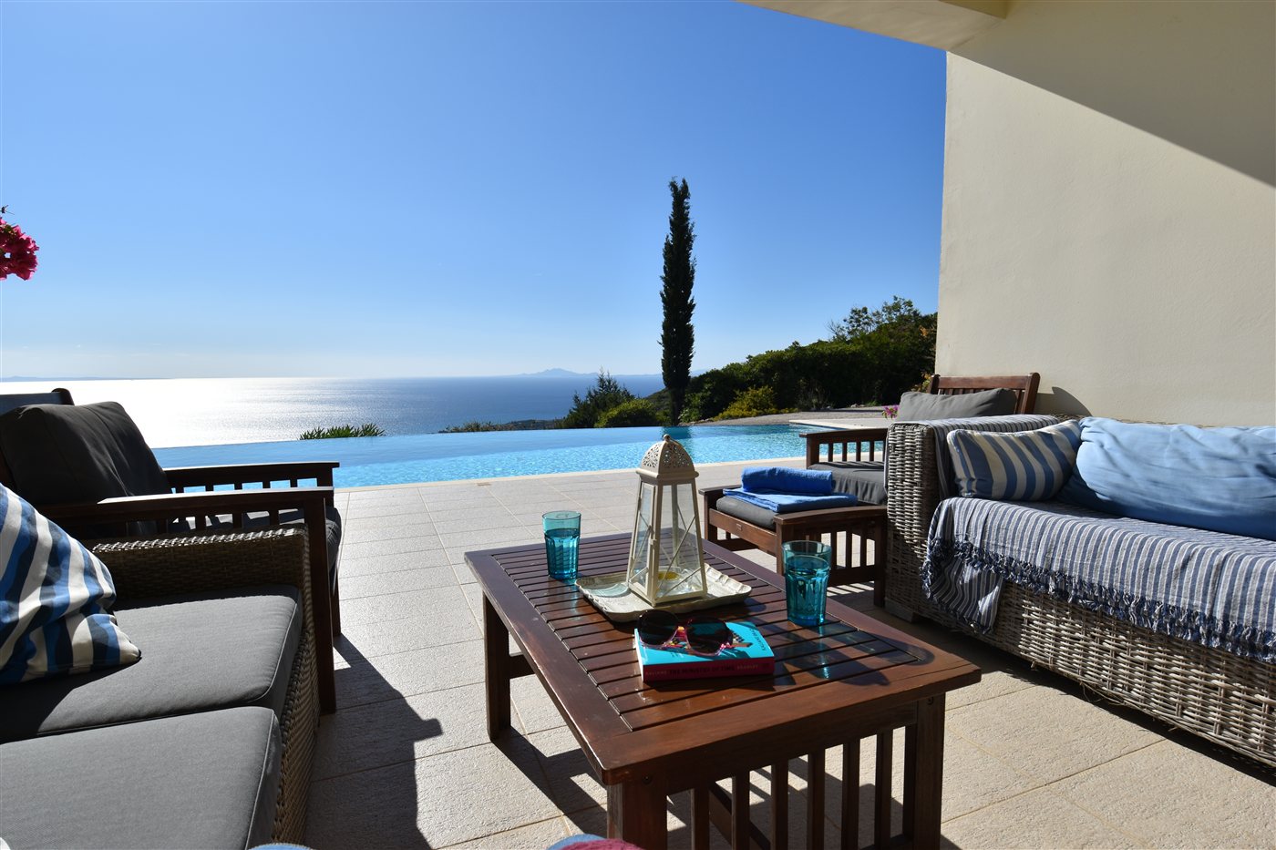 Shaded terrace sofas looking across the private pool towards the sea